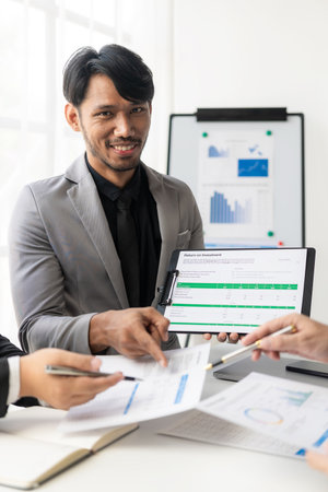 Young asian business people financial analysis meeting brainstorming on new business together with laptop and financial accounting graph papers in officeの写真素材