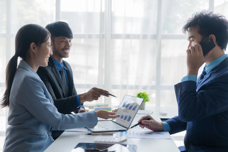 Young asian business people financial analysis meeting brainstorming on new business together with laptop and financial accounting graph papers in officeの写真素材