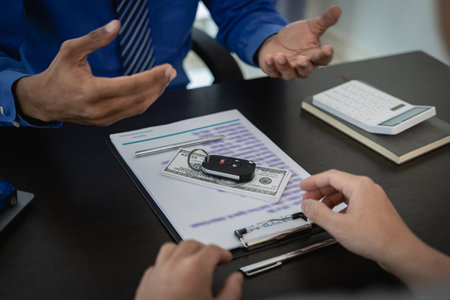 Signing a car insurance document or a rental agreement or agreement. Buy or sell a new or used car with car keys on the table in the office. close up picturesの写真素材