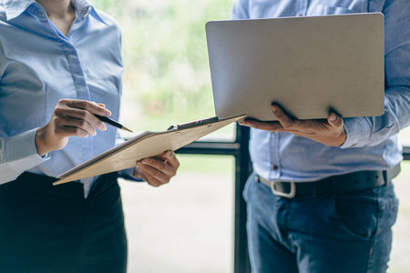 Two businessmen sitting at desk using digital tablet and laptop working together at modern office close-up business colleagues working together close up picturesの写真素材