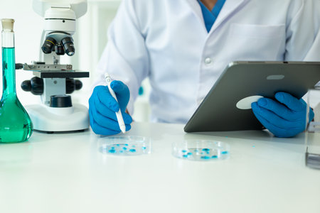 Drug research in chemistry lab, chemical scientist working with microscope, analyzing liquid testing using beaker tubes, medical laboratory conceptの写真素材