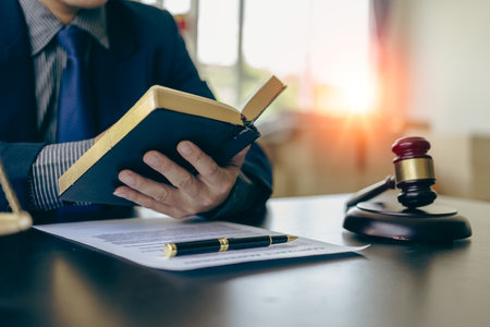 Male lawyer working with judge's gavel and golden scales in law officeの写真素材