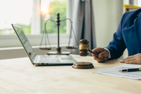 Male lawyer working with judge's gavel and golden scales in law officeの写真素材