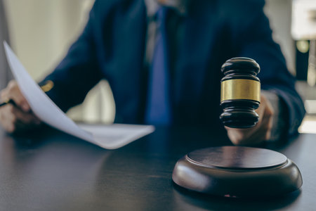Male lawyer working with judge's gavel and golden scales in law office
