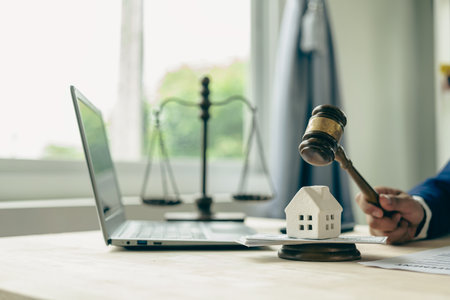 House auction concept: Judge holding a gavel to decide the house's sale at auction.の写真素材