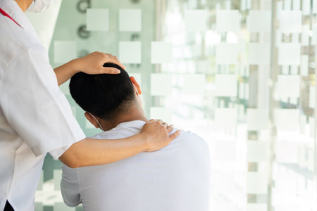 Physical therapist working on the treatment of the injured arm of an Asian male athlete patient. Stretch and exercise Perform pain rehabilitation therapy in the medical clinic.の写真素材