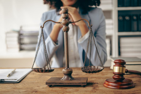 Attractive young African American lawyer working in the office with contract and legal documents when sitting at the table. Law, legal services, advice, justice.の写真素材