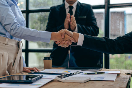 Businessmen join hands for teamwork in business mergers and acquisitions, successful negotiations, with partners celebrating partnership. Close-up picturesの写真素材