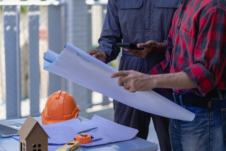 Concept architect, engineer, team holding pen, pointing architect, equipment on table with...