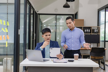 Angry businessman arguing with businessman about document failure at work Executives conflict over responsibility for poor performance, stressful meeting conceptの写真素材