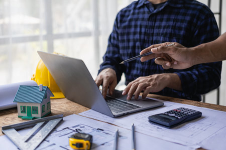 Group of engineers and working meeting and discussing construction planning with blueprints with architect equipment. Architects talking at table, teamwork and work flow constructiの写真素材