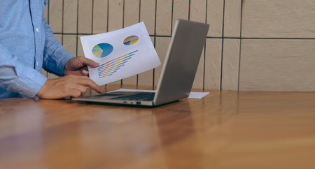 Accountant holding documents preparing performance analysis report Executives create documents at work using online computer software for analyzing financial data. Close-up pictureの写真素材