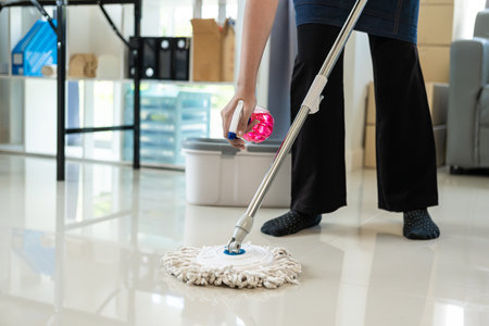 Maid wearing an apron provides cleaning services at home. Close-up of a young woman cleaning a new...