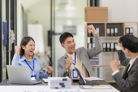 A team of Asian businessmen is excited about the success of their new venture.の写真素材