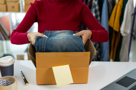SME Startup, small business, female entrepreneur, working, unpacking, checking orders online To prepare to pack boxes to sell to customers with online business ideas from afar.の写真素材