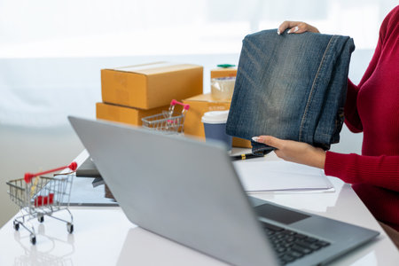 SME Startup, small business, female entrepreneur, working, unpacking, checking orders online To prepare to pack boxes to sell to customers with online business ideas from afar.の写真素材
