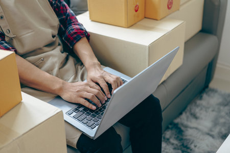 Close up of young man using laptop for online shopping at home.の写真素材