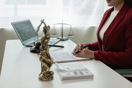 Asian female lawyer working in office or court with hammer and justice pad on table, online legal advice with new laws of real estate business. Law, legal service, advice, justice.の写真素材
