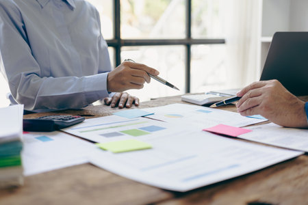 A team of analysts works on a financial data analysis dashboard on paper to use as market indicators for planning, strategic brainstorming, financial investments and marketing newの写真素材