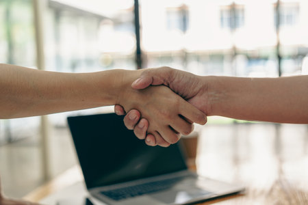 Business people shaking hands and meeting with the above documents to hire a partner or work...