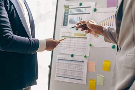 Group of people of different nationalities working in a conference room in a business presentation or seminar. The documents include financial figures, graphs, charts and laptop clの写真素材