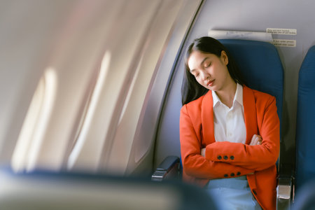 Young asian businesswoman in airplane cabin. Business travel concept.