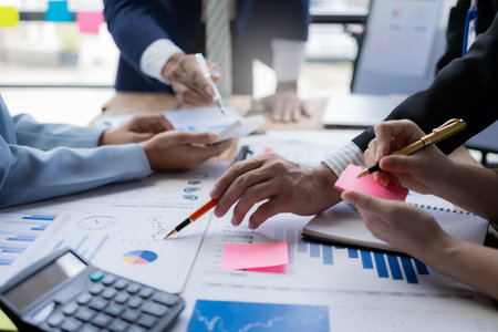 Business people discussing the charts and graphs showing the results of their successful teamworkの写真素材