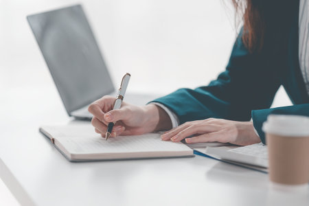 Confident businesswoman working on laptop in her office, female accountant or banker doing calculations Concept of savings, finance and economy Close-up picturesの写真素材