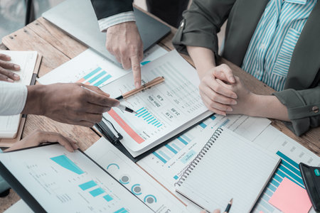 Business meeting, various international executives discuss reports at the meeting table, project negotiation committee develops business strategies by analyzing documents, graphs,の写真素材