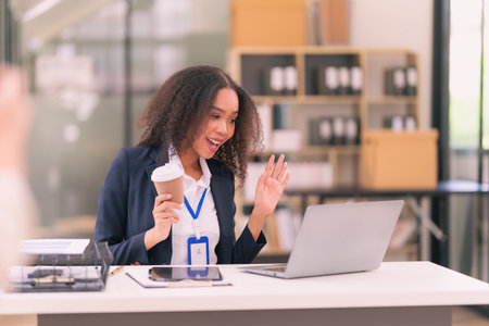 Female accountant uses calculator and holds pen for calculating business data. Business woman looks at laptop screen, calculates expenses, pays taxes online, financial documents.の写真素材