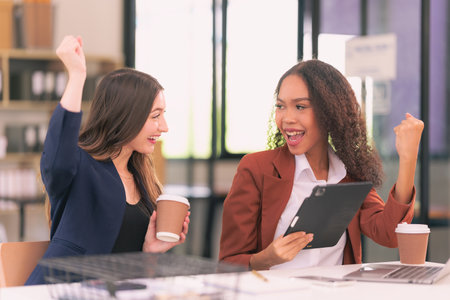 Successful businesswomen are celebrating the success of their work in the office.の写真素材