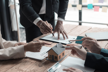 A real estate agent is explaining the layout of a house to a client who is about to buy a new apartment along with insurance interest rates on the title. Close-up photoの写真素材