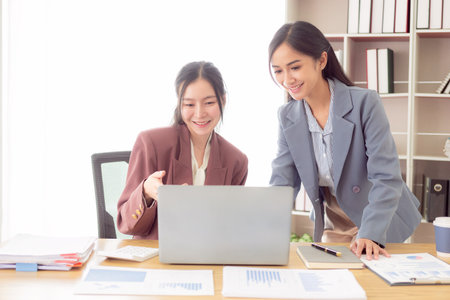 Two Asian accountants brainstorming on financial charts
Financial advisors or analysts discuss financial reports together.の写真素材