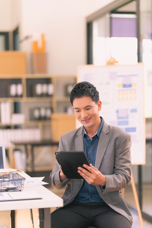 portrait of young asian businessman using tablet computer in modern officeの写真素材