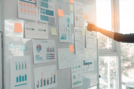 Businessmen discuss charts and graphs showing successful teamwork. Close-up of a team of Business Colleagues analyzing financial data at a table in the office.の写真素材