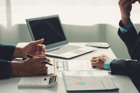 Business people discuss charts and graphs showing successful teamwork in data company growth proposal. Analytical statistics, infographics and strategy ideasの写真素材