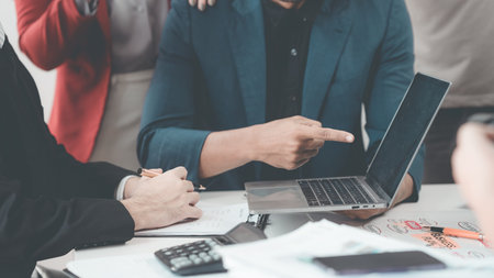 Business people discuss charts and graphs showing successful teamwork in data company growth...