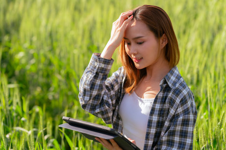 Asian farmer woman and tablet holding hands checking barley quality Using modern technology to check the quality of barley on the farm technology conceptの写真素材