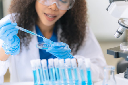 Beautiful African female doctor sitting at table in science lab with test flasks Colorful glass...
