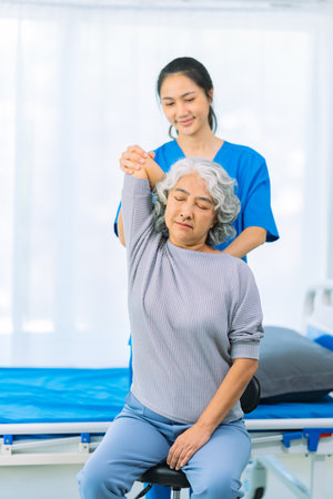 An elderly Asian female patient is happy and smiles, encouraging and supporting her to do physical therapy to walk. Health care conceptの写真素材