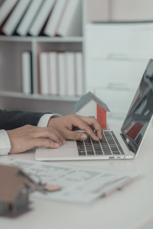 A real estate salesperson introduces a customer to a model home project and hands the keys to the customer. New home buyer approved for home loan, close-up photoの写真素材