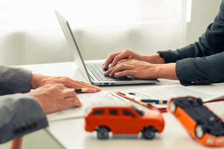 Insurance agent and red toy car on table Transportation financial cost management planning Concept of car insurance businessの写真素材
