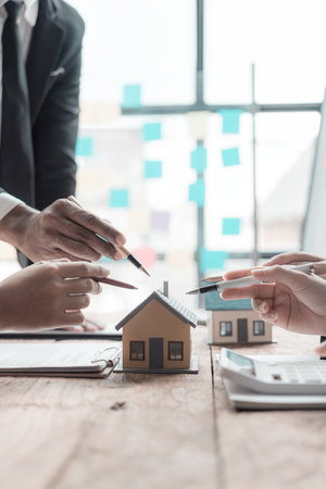 Female real estate agent presenting and giving advice on details of house and model building projects in the office.の写真素材