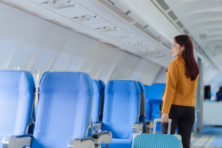 Beautiful Asian woman travels by plane to foreign countries for vacation. The atmosphere inside the plane. A woman makes various poses on the plane.の写真素材