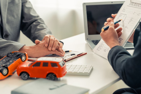 Car dealer and customer signing car insurance contract, analyzing car loan options, signing lease contract for car transaction, close up.の写真素材