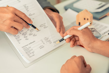 A real estate agent discusses the terms of a home purchase contract and asks the client to sign a...