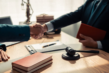 Lawyer team presenting signed contract document to client in office. Law, judge, court, law concept. Judge's gavel with scales of justice. Close up.の写真素材