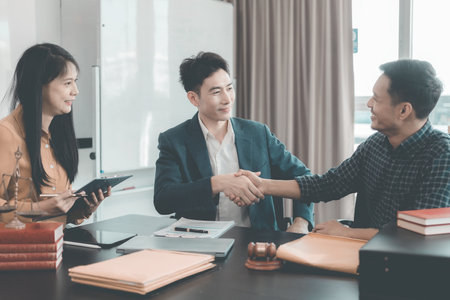 Businessmen shaking hands to make a deal with their partner lawyer, discussing contract agreement, legal concept, advice and justice, good service cooperation.の写真素材