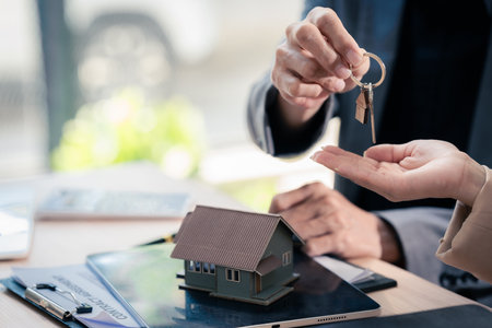 Real estate agent handing over keys to new home, analyzing mortgage loan and interest rate insurance, investment planning, real estate, home buying and selling concept, close upの写真素材