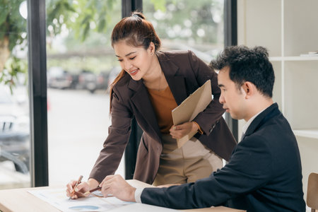 Business men and women discussing charts and graphs showing results of successful teamwork using laptops. Business strategy planning and brainstorming.の写真素材